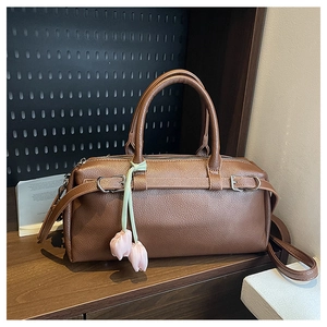 Detail of brown litchi pattern leather bag with pink tulip charms and metal hardware