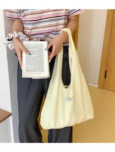 Close-up of casual yellow floral tote bag made of cotton canvas with a front woven label