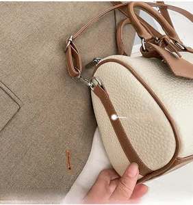 Detail shot of meticulous stitching on off-white lychee texture faux leather bag