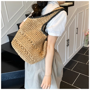 Close-up of a large capacity straw tote bag with black trim detailing and hollow weave