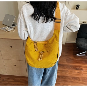 Detailed back view of a bright yellow canvas crossbody bag with adjustable wide shoulder strap
