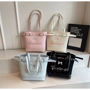 Détail de quatre sacs fourre-tout colorés avec broderie et nœud 3D sur socle blanc