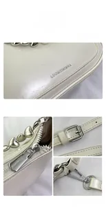 Detail view of cream leather shoulder bag with heart-shaped metal chain and silver hardware