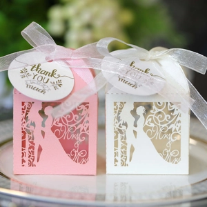 Laser-cut wedding favor boxes in pink and white with ribbons and thank you gift tags