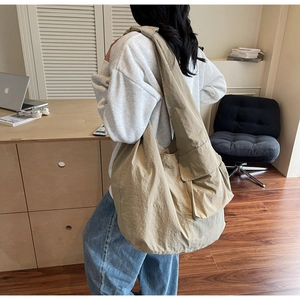 Detail of khaki nylon tote bag showing side flap pocket and large capacity structure