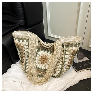 Detail of bohemian crochet tote bag featuring sun flower knit pattern and woven handles