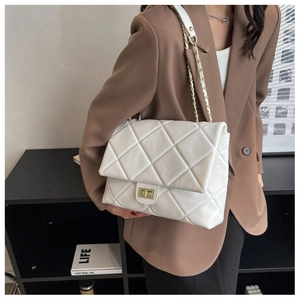 Detail of white quilted leather bag with gold rectangle turn-lock and chain strap
