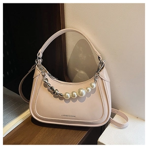Détail d'un sac demi-lune rose avec chaîne en perles et cœurs et bandoulière réglable