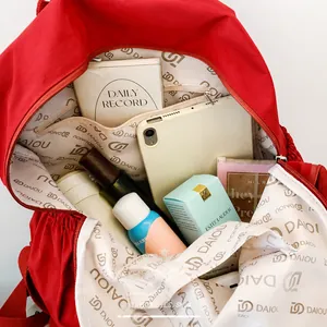 Vista detallada del interior espacioso de la mochila roja con forro de logo y compartimentos