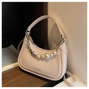Close-up of elegant white underarm bag featuring decorative pearl and heart chain detail