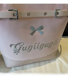 Détail du sac cabas rose avec broderie de nœud argenté et logo sur le devant
