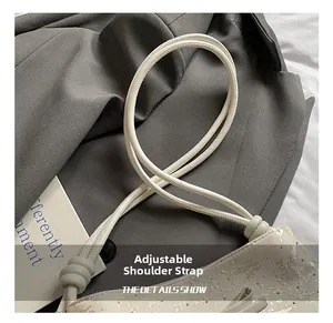 Detail showing the adjustable thin shoulder strap and silver textured faux leather material