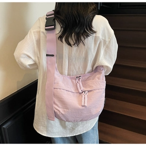 Detail of purple crescent canvas bag with wide strap and woven zipper pullers