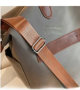 Détail de la bandoulière réglable et boucle en métal sur le sac fourre-tout en nylon