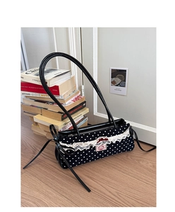 Détail du sac à main rétro à pois avec bordure en dentelle et nœud rouge chic