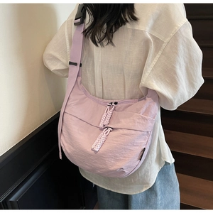 Detail of lavender crescent canvas bag showing textured fabric and dual braided rope zippers