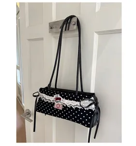 Vue détaillée du sac à pois noir avec bordure en dentelle et nœud en cuir décoratif