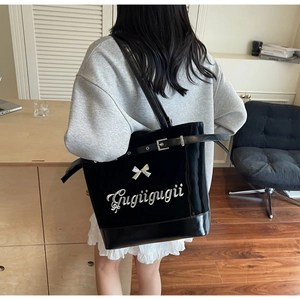 Détail du grand sac cabas noir avec nœud, broderie argentée et bandoulière à boucle