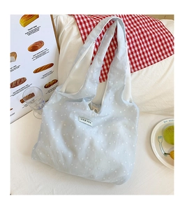 Detailed shot of light blue floral seersucker tote bag with delicate white flower pattern