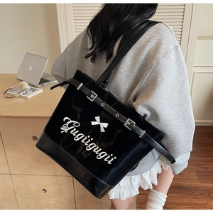 Détail du sac cabas en cuir verni noir avec nœud blanc et imprimé lettrage Gugiigugii
