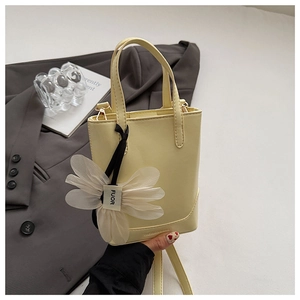 Detail of yellow bucket bag with floral charm and Fashion & Bag embossed logo