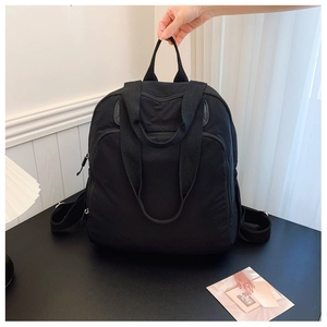Primer plano detallado de una mochila de nailon negro con compartimento principal y cremallera