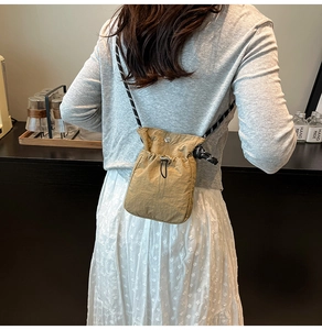 Détail du mini sac bandoulière en nylon kaki avec cordon et sangle tissée sur modèle