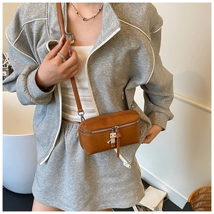 Detail view of brown vintage mini crossbody bag featuring a cute robot metal keychain