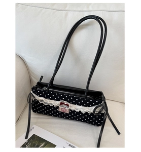 Vue détaillée du sac à pois avec bordure en dentelle blanche et nœuds en ruban rouge