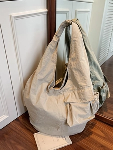 Large khaki hobo tote bag with wide shoulder strap and functional utility pockets