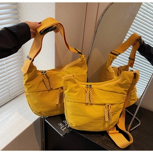 Macro detail of bright yellow nylon half-moon bag with woven zipper and strap