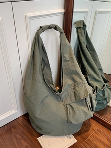 Army green large nylon hobo bag with multi-pocket utility design and knotted shoulder strap
