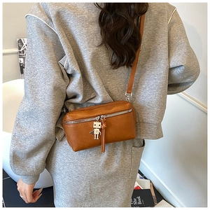 Detail of brown PU leather crossbody bag featuring a cute robot charm and silver zipper
