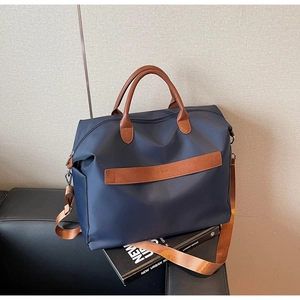Détail du grand sac cabas bleu marine avec poignées en cuir marron et bandoulière