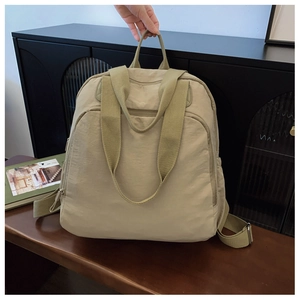 Primer plano de la mochila de nailon beige acolchada con bolsillos y correas anchas