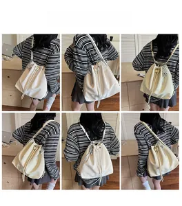 Detail view of cream drawstring backpack showing glossy leather texture and model usage