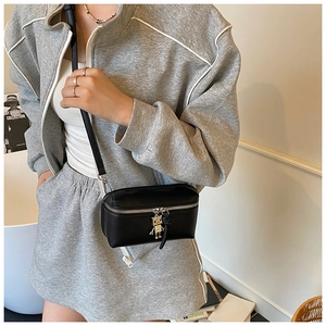 Detail of black mini crossbody box bag with silver robot charm on a model