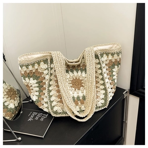 Detail of bohemian crochet tote bag featuring vintage floral patterns and woven handles