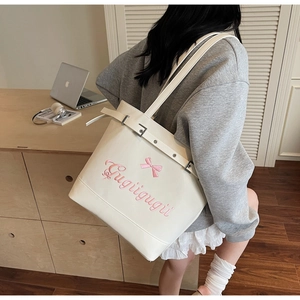 Détail d'un grand sac blanc avec broderie nœud rose et boucle métallique argentée chic