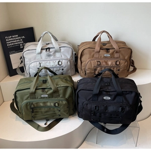 Detailed view of multi-color travel duffel bags in grey, brown, green and black colors
