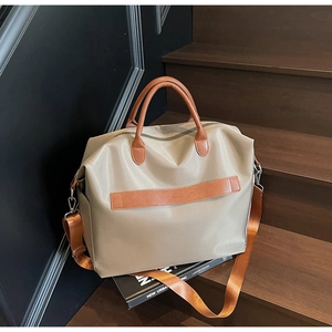 Détail du sac cabas en nylon kaki avec poignées en cuir et bandoulière réglable