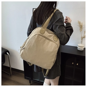 Vista lateral de mujer con mochila caqui minimalista de gran capacidad y versátil