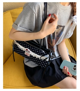 Détail du sac sous l'aisselle à pois noirs avec bordure en dentelle et ruban
