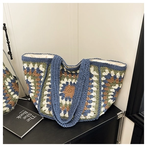 Close-up of bohemian crochet tote bag featuring colorful sunflower patterns and knit handles