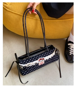 Détail du sac à main à pois avec bordure en dentelle et un nœud rouge vif élégant