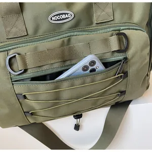 Close-up of olive green travel bag showing spacious front zipper pocket and logo