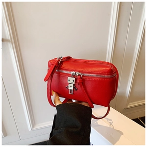 Detail of red mini crossbody box bag featuring a silver metal robot charm and leather strap