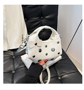 Détail du sac à main blanc en cuir avec rivets argentés et un nœud décoratif élégant