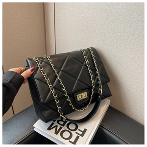 Close-up of the black quilted texture with gold chain strap and metal swivel lock