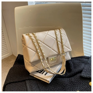 Close-up of cream quilted shoulder bag with gold chain strap and metal turn-lock closure